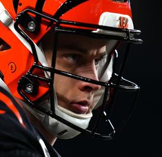 a close up of a football player wearing a helmet with an orange and white stripe