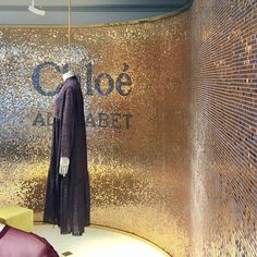 a mannequin is standing in front of a wall with gold sequins