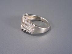 This beautiful sterling ring has two rows of clear cubic zirconia round stones in graduated size with a row of channel set square aka princess cut in the center. The ring is a size 8 and the front center vertically measures 11mm wide. Mark: 925 DQ CZ China and has been tested to ensure sterling silver purity. In wonderful condition, the stones are not damaged and have a nice sparkle, some light usage marks on the shank of the ring. Sarah Coventry, Cz Ring, Channel Set, Multi Stone Ring, Butterfly Necklace, Halo Rings, Princess Cut, Sterling Ring, Vintage Necklace