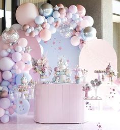 there is a pink and white party with balloons on the wall, stars in the background