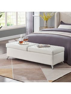 a white ottoman bed with two trays on it