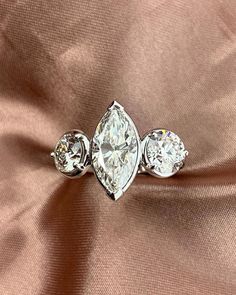 three stone diamond ring on satin fabric