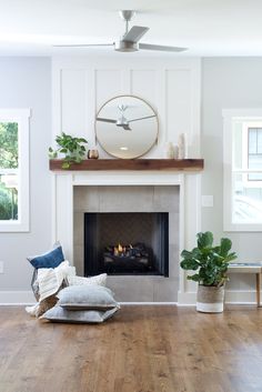 a living room filled with furniture and a fire place under a clock mounted on the wall