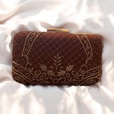 Elevate your ensemble with this exquisite handmade box clutch, a perfect fusion of traditional artistry and contemporary elegance. Crafted from luxurious raw silk, this clutch is adorned with intricate hand-embroidered zardozi and beadwork, showcasing the timeless beauty of this ancient technique. The detailed embroidery adds a touch of opulence, making it an ideal accessory for any special occasion. The clutch features a premium metal frame and a sleek rectangular knob, ensuring both durability Luxury Handmade Antique Bags, Rectangular Clutch With Intricate Embroidery For Receptions, Traditional Embroidered Evening Bag For Formal Events, Traditional Embroidered Evening Bag For Formal Occasions, Elegant Evening Bag For Receptions And Festivals, Festive Rectangular Clutch For Wedding, Traditional Embroidered Formal Evening Bag, Elegant Evening Bag For Wedding And Festivals, Rectangular Openable Clutch For Reception