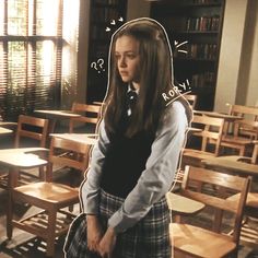 a girl in a school uniform standing in front of desks