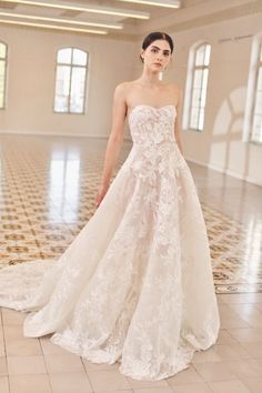 a woman in a wedding dress standing on a tile floor