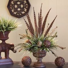 two vases filled with plants on top of a table next to an elephant figurine