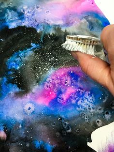 someone is holding a paintbrush and painting the outer part of an image with stars