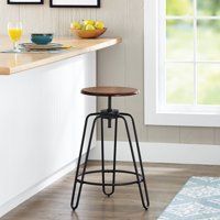 a kitchen with a counter, stool and pictures on the wall