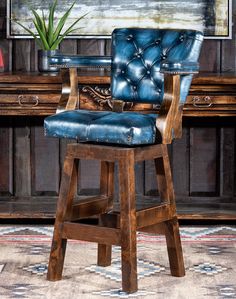 a blue leather bar stool sitting in front of a desk with a potted plant