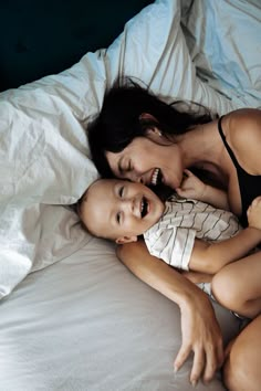 a woman and child laying in bed together