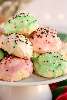 a white plate topped with cookies covered in frosting and sprinkles on top of a table