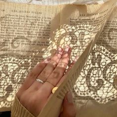 a person's hand on top of an open book with sunlight streaming through it