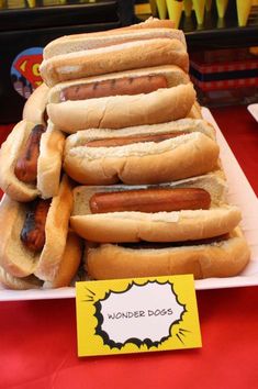 a bunch of hotdogs are stacked on top of each other in a white plate