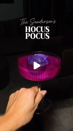 a person holding a wine glass in their hand with the words hoccus pocus on it