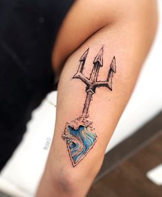 a woman with a tattoo on her arm holding a heart and two arrows in the middle