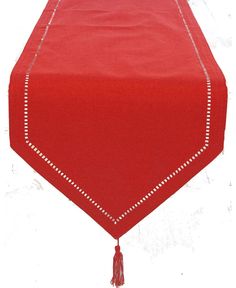 a red table runner with tassels on the edge and white stitching at the edges