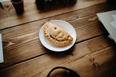 a piece of pie sitting on top of a white plate next to a brown bag