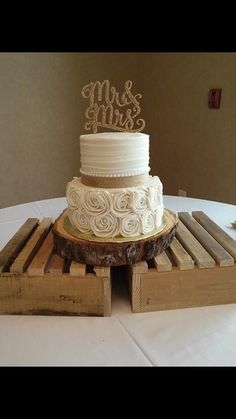 a wedding cake sitting on top of a wooden pallet with mr and mrs written on it