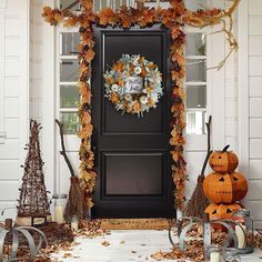 a front door decorated for halloween with pumpkins and other decorations