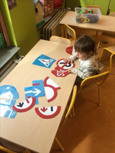 a young child is sitting at a table with several signs on it that spell out the word stop