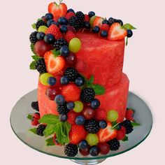 a watermelon cake with berries and grapes on top