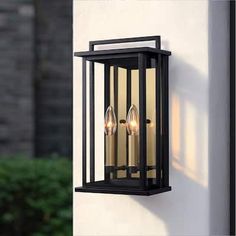 an outdoor wall light with two candles on it