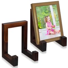 two wooden frames sitting next to each other on top of a white surface with a small child's picture in the middle