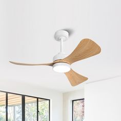 a white ceiling fan with wooden blades in a room