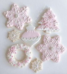 decorated cookies are arranged in the shape of snowflakes and christmas tree ornaments on a white surface