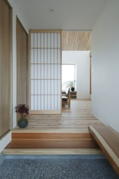 an empty room with wooden steps leading up to the door, and a potted plant on the floor