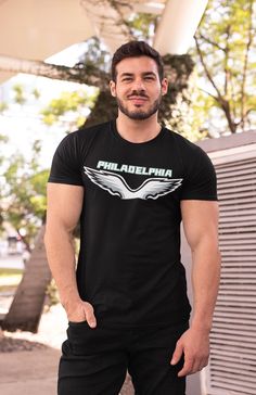 Our Philadelphia Eagle T-shirt is a stylish and comfortable option for devoted fans. This Cut and Sew Black T-shirt is designed to showcase your unwavering support for the Eagle while keeping you looking sharp. This Philly Teams Shirt is the perfect way to represent your love for Philadelphia football. This Game Day Shirt offers a soft feel and a relaxed fit, making it ideal for all-day wear. The cut-and-sew design provides a modern look that sets this shirt apart from the rest. With its short sleeves, this Football Shirt is perfect for layering or wearing on its own, ensuring you stay comfortable throughout the game. The bold Eagle graphic prominently displayed on the shirt is a fantastic way to show off your team spirit. This shirt is sure to catch the attention of everyone around you. I Fan Apparel Crew Neck T-shirt With Front Print, Fan Apparel T-shirt With Front Print And Crew Neck, Fan Apparel T-shirt With Crew Neck And Front Print, Fan Apparel T-shirt With Front Print, Urban Crew Neck T-shirt For Fan Merchandise, Black T-shirt With Sublimation Print For Fans, Front Print Cotton T-shirt For Fan Gear, Cotton T-shirt With Front Print For Fans, Band Merch Cotton T-shirt For Fans