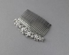 This beautiful floral hair comb is a cast design plated in rhodium and created with high-quality crystal stones. Use it as a side accent or back piece for a simple statement in your wedding hairstyle.

Austrian crystal stones
rhodium plated brass
3 inches by 1/2 inches high