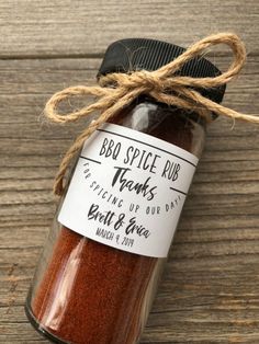 a jar filled with red spice sitting on top of a wooden table next to a string