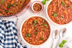 three bowls of beans and carrots on a white surface with spoons, salt and pepper