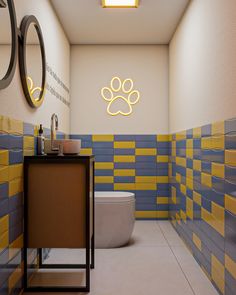 a bathroom with yellow and blue tiles on the walls