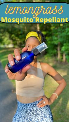 a woman is holding a blue bottle in her right hand and the words lemongrasss mosquito repellent on it