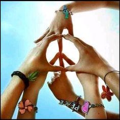 four people holding their hands together in the shape of a peace sign