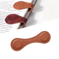 a bookmark with a leather band on top of an open book