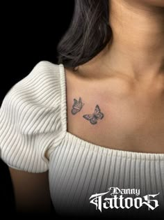 a woman's chest with two butterflies tattoo on her left side ribcage