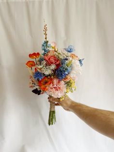 a person holding a bouquet of flowers in their hand