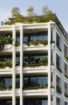 an apartment building with plants growing on the balconies