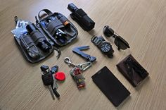 an assortment of personal items laid out on a wooden table with sunglasses, keys, and wallet