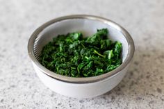 a bowl filled with green vegetables on top of a table