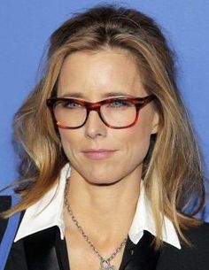 a woman wearing glasses and a black suit