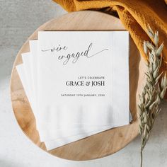 three napkins sitting on top of a wooden plate next to an orange towel and a plant