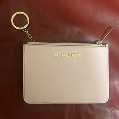 a white michael kors wallet with a keychain hanging from it's side