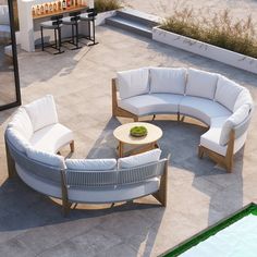 an outdoor seating area with white furniture on the ground and sand in the background,