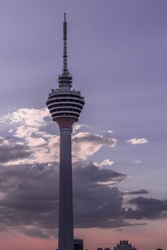 a tall tower with a sky background and clouds in the foreground at dusk or dawn