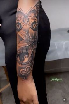 a woman with a black and grey tattoo on her arm